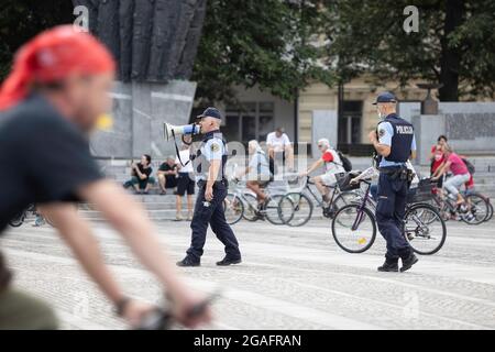 Ljubljana, Slovénie. 30 juillet 2021. Un policier avertit les manifestants des restrictions actuelles de Covid-19 et des mesures prises à travers un mégaphone, lors des manifestations cyclistes du vendredi contre le gouvernement du Premier ministre Janez Jansa. Crédit : SOPA Images Limited/Alamy Live News Banque D'Images