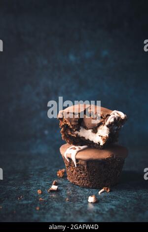 Cupcakes au chocolat crème, sur fond bleu foncé. Banque D'Images