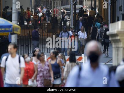 New York, États-Unis. 30 juillet 2021. Certains piétons portent un masque facial et certains ne le font pas lorsqu'ils marchent sur Wall Street à New York le vendredi 30 juillet 2021. Photo de John Angelillo/UPI crédit: UPI/Alay Live News Banque D'Images