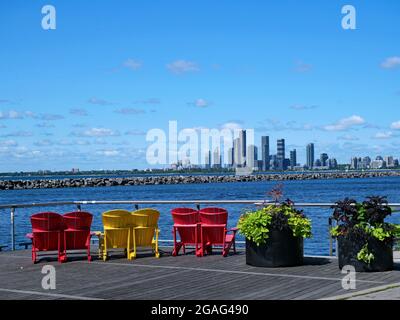 Chaises colorées sur la promenade en bord de mer de Toronto, avec vue sur les immeubles modernes d'appartements en copropriété dans l'ouest Banque D'Images