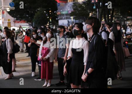 Tokyo, Japon. 30 juillet 2021. Les piétons portant un masque facial attendent un feu vert à l'intersection de Shinjuku. 3300 personnes ont été testées positives pour le nouveau coronavirus (Covid-19) le huitième jour des Jeux Olympiques de Tokyo 2020 pendant l'état d'urgence à Tokyo. Crédit : SOPA Images Limited/Alamy Live News Banque D'Images