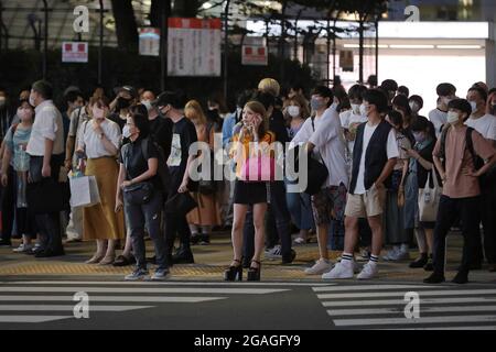 Tokyo, Japon. 30 juillet 2021. Les piétons portant un masque facial attendent un feu vert à l'intersection de Shinjuku. 3300 personnes ont été testées positives pour le nouveau coronavirus (Covid-19) le huitième jour des Jeux Olympiques de Tokyo 2020 pendant l'état d'urgence à Tokyo. Crédit : SOPA Images Limited/Alamy Live News Banque D'Images