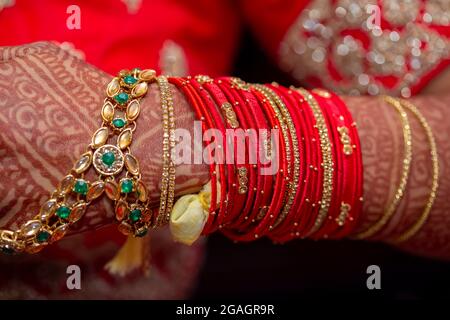 Bijoux de mariée traditionnel et décoration au henné sur les mains de la mariée durant une cérémonie religieuse à un mariage hindou Banque D'Images