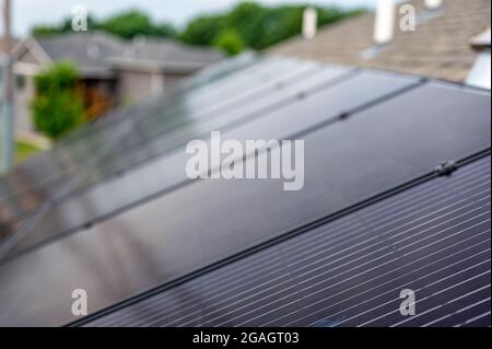 Accent sélectif sur les panneaux solaires installés sur un toit de bardeaux en asphalte résidentiel Banque D'Images