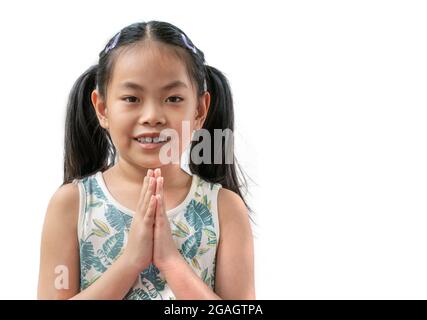 Portrait de l'enfant asiatique fille est salutation en Thaïlande style traditionnel qui a appelé Sawatdee. Style asiatique de message d'accueil par la main. Enfant fille à Banque D'Images