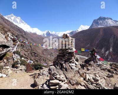 Drapeaux de prière tibétains et pierre de cairns surplombant Dingboche et la vallée de la rivière Imja Khola, avec le Mont Lhotse sur la gauche, parc national de Sagarmatha, Népal Banque D'Images