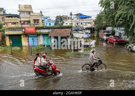 Kolkata, Inde. 30 juillet 2021. Les gens qui traversent une route engortée par l'eau au lendemain. Kolkata a reçu la plus grosse baisse de la saison causée par un système de basse pression au-dessus du Bangladesh et du Bengale occidental. Crédit : SOPA Images Limited/Alamy Live News Banque D'Images