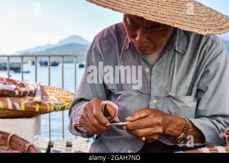 Hong Kong, Chine. 29 octobre 2018. Un homme âgé a vu éplucher un poisson séché dans l'île Cheung Chau. (Photo par Andriy Andriyenko/SOPA Images/Sipa USA) crédit: SIPA USA/Alay Live News Banque D'Images