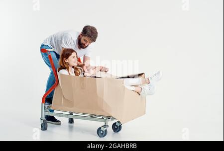 un homme roule une femme sur un chariot dans une boîte Banque D'Images