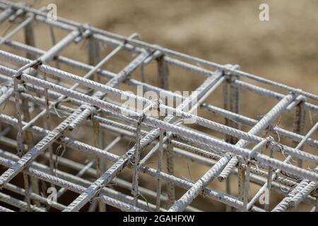 Image de faible profondeur de champ (mise au point sélective) avec acier utilisé pour le renforcement du béton, sur un chantier de construction. Banque D'Images