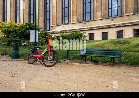 PAR, FRANCE - 08 juillet 2021 : un vélo électrique garée devant le grand bâtiment de Paris, France - concept d'alternative écologique contre Banque D'Images