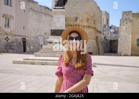 Une jeune fille touristique décontractée se promenant dans la vieille ville d'Otranto, Apulia, Italie Banque D'Images