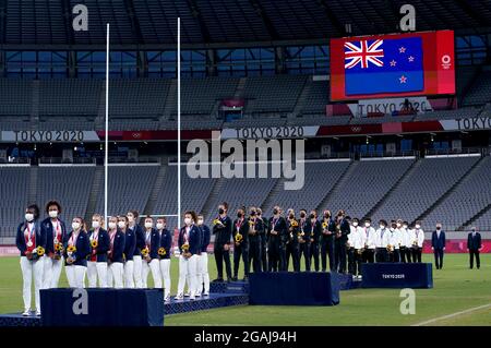 Les joueurs néo-zélandais (au centre) observent leur hymne national après avoir reçu leurs médailles d'or pour avoir remporté le match de médaille d'or des femmes de rugby à sept contre la France au stade de Tokyo le huitième jour des Jeux Olympiques de Tokyo en 2020 au Japon. Date de la photo: Samedi 31 juillet 2021. Banque D'Images