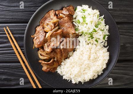 Sauce au porc japonaise Shogayaki avec sauce au gingembre râpé, riz et chou ou salade dans l'assiette sur la table. Vue horizontale du dessus de a Banque D'Images