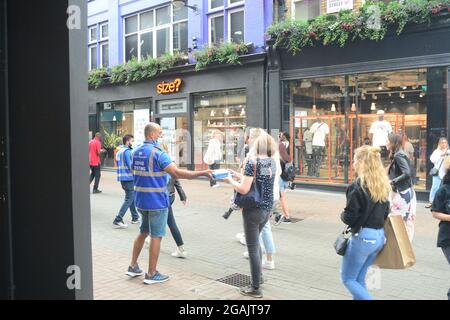 Londres, Royaume-Uni. 31 juillet 2021. Un employé du conseil remet un kit de test Covid à un client sur Carnaby St. à Londres. Crédit : graham mitchell/Alamy Live News Banque D'Images