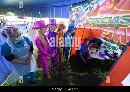 Dre Lisa Pickles, 57 ans (à gauche), responsable clinique du programme de vaccination de Caldove, présente des artistes de Circus Extreme comme leur collegue Ryan Dobie, 24 ans, qui a reçu une vaccination Covid-19 dans une clinique de vaccination pop-up dans le chapiteau du cirque à Halifax. Date de la photo: Samedi 31 juillet 2021. Banque D'Images