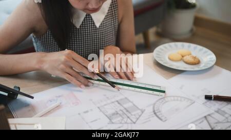 Coupe courte femme travaillant sur un projet d'architectes à la maison. Banque D'Images