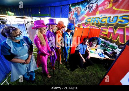 Dre Lisa Pickles, 57 ans (à gauche), responsable clinique du programme de vaccination de Caldove, présente des artistes de Circus Extreme comme leur collegue Ryan Dobie, 24 ans, qui a reçu une vaccination Covid-19 dans une clinique de vaccination pop-up dans le chapiteau du cirque à Halifax. Date de la photo: Samedi 31 juillet 2021. Banque D'Images