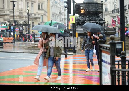 31 juillet 2021, Londres, Royaume-Uni. Les gens se réfugient sous des parasols pendant une période de forte pluie crédit: graham mitchell/Alay Live News Banque D'Images