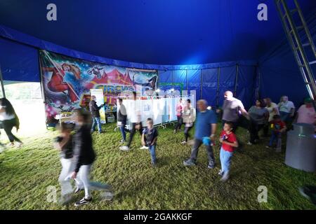 Les gens qui fréquentent Circus Extreme à Halifax, marchent devant une clinique pop-up de vaccination Covid-19 établie dans le chapiteau du cirque. Date de la photo: Samedi 31 juillet 2021. Banque D'Images