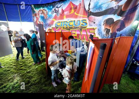 Les personnes qui fréquentent Circus Extreme à Halifax, attendent d'être vaccinées dans une clinique de vaccination Covid-19 établie dans le chapiteau du cirque. Date de la photo: Samedi 31 juillet 2021. Banque D'Images