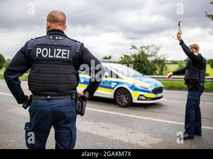 Emmerich, Allemagne. 31 juillet 2021. Un agent de police est muni d'un dispositif d'arrêt de police lors d'un contrôle d'entrée Corona effectué par la police fédérale à la frontière germano-néerlandaise et vérifie les véhicules dans la zone frontalière. Credit: Guido Kirchner/dpa/Alay Live News Banque D'Images