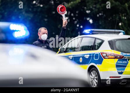 Emmerich, Allemagne. 31 juillet 2021. Un agent de police est muni d'un dispositif d'arrêt de police lors d'un contrôle d'entrée Corona effectué par la police fédérale à la frontière germano-néerlandaise et vérifie les véhicules dans la zone frontalière. Credit: Guido Kirchner/dpa/Alay Live News Banque D'Images