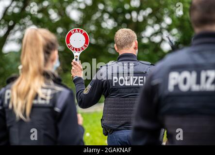 Emmerich, Allemagne. 31 juillet 2021. Un agent de police est muni d'un dispositif d'arrêt de police lors d'un contrôle d'entrée Corona effectué par la police fédérale à la frontière germano-néerlandaise et vérifie les véhicules dans la zone frontalière. Credit: Guido Kirchner/dpa/Alay Live News Banque D'Images