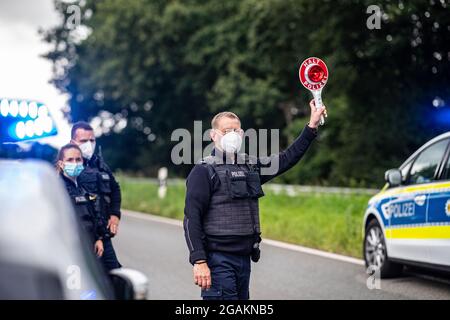 Emmerich, Allemagne. 31 juillet 2021. Un agent de police est muni d'un dispositif d'arrêt de police lors d'un contrôle d'entrée Corona effectué par la police fédérale à la frontière germano-néerlandaise et vérifie les véhicules dans la zone frontalière. Credit: Guido Kirchner/dpa/Alay Live News Banque D'Images