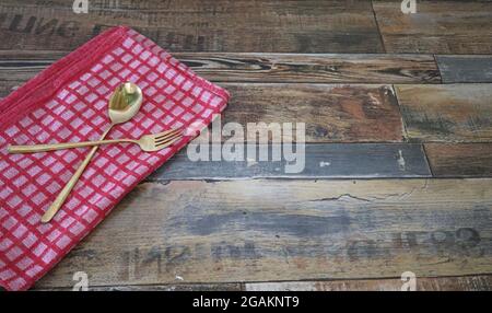 Chiffon rouge et cuillère dorée sur table en bois Banque D'Images