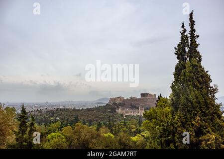 Colline de l'Acropole (Parthénon, Propylaea, temples, Odéon d'Herodes Atticus) et vue sur la ville blanche à travers la verdure et les arbres. Athènes ancien LAN historique Banque D'Images