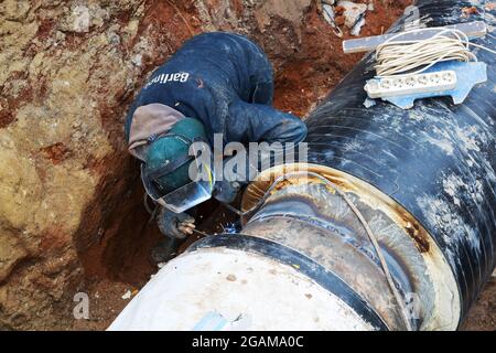 Odessa, Ukraine - 11 octobre 2016 : réparation du conduit de chauffage. Les ouvriers, soudeurs réalisés par soudage électrique et soudage au gaz sur de grands tuyaux en fer à un dep Banque D'Images