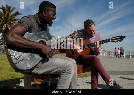 Un autre musicien et ami Nog (à droite) se joignant à Tom Sibanda (à gauche) dans une quête de lever des fonds pour payer son loyer le dernier jour du mois. Banque D'Images