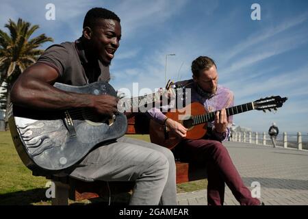 Un autre musicien et ami Nog (à droite) se joignant à Tom Sibanda (à gauche) dans une quête de lever des fonds pour payer son loyer le dernier jour du mois. Banque D'Images