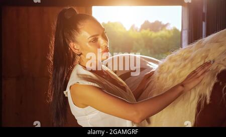 Jeune femme brunette avec de longs cheveux en queue de cheval animaux de compagnie Banque D'Images