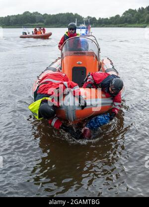 Hochdonn, Allemagne. 31 juillet 2021. Les agents de la police des eaux tentent de prendre une activiste de natation qui tient sur la coque de son bateau à moteur sur le canal de Kiel. Lors d'une manifestation contre un terminal prévu pour le gaz naturel liquéfié (GNL) à Brunsbüttel, des activistes ont occupé des voies dans une zone industrielle et bloqué le canal de Kiel avec des bateaux. Credit: Jonas Walzberg/dpa/Alay Live News Banque D'Images