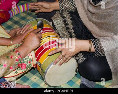 Deux dames jouant avec le tambour indien à double tête qui est connu sous le nom de dholki Banque D'Images