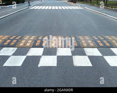 Une bosse de vitesse sur la route de la ville, une barrière d'asphalte, un obstacle de sécurité avant le passage pour piétons Banque D'Images
