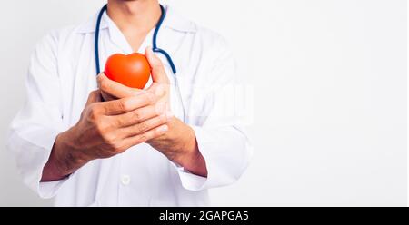 Gros plan Homme médecin avec stéthoscope il tient rouge cœur à la main isoler sur fond blanc Banque D'Images