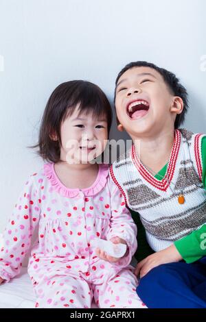 Petits enfants asiatiques (thaïlandais) heureusement, frère riant et sœur souriant sur fond de mur blanc, image conceptuelle sur l'amour et le collage de sibli Banque D'Images