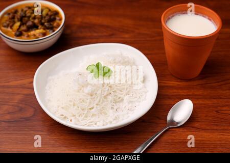 Noolappam/Idiyappam/nouilles de riz, un plat traditionnel populaire de Kerala cuit à la vapeur avec curry chaud et épicé de rôti d'oeuf sur une péniche, Alleppey Banque D'Images