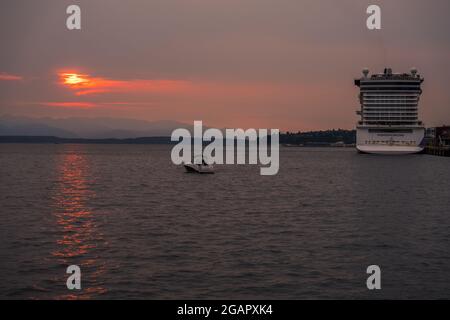 Seattle, États-Unis. 31 juillet 2021. Un coucher de soleil fumé au-dessus d'Elliott Bay et le bateau de croisière Norwegian encore amarré à l'embarcadère 66. Climat la fumée de feu du pacifique nord-ouest les feux de forêt ont commencé à descendre sur Seattle hier et fait pour de beaux couchers de soleil d'or. Seattle se débat désormais avec des cieux étouffés, tandis que les feux de changement climatique font rage chaque année dans toute la région. James Anderson/Alay Live News Banque D'Images