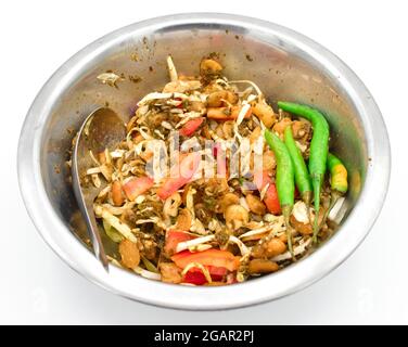 Salade de feuilles de thé birmane ou lahpet avec piments verts et rouges, recette d'ail. Isolé sur blanc. Banque D'Images