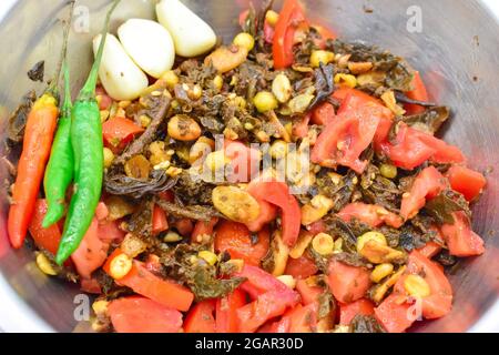 Salade de feuilles de thé birmane ou lahpet avec piments verts et rouges, recette d'ail. Vue en gros plan. Banque D'Images