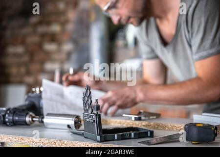 Gros plan d'un ensemble de forets à bois sur une table de travail d'un menuisier dans un atelier. Banque D'Images