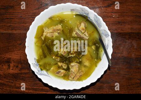 Recette de soupe à la moutarde blanche aigre avec côtes de porc. Cuit en Asie, au Myanmar. Banque D'Images