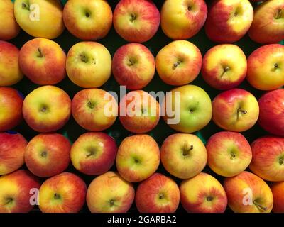 Les pommes Cox sont disposées en pile dans un supermarché pour la vente. Image d'arrière-plan des fruits de pomme. Banque D'Images