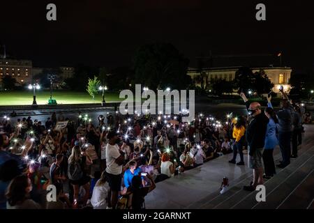 Washington, DC, États-Unis. 1er août 2021. Photo : les manifestants lors d'un rassemblement de minuit sur les marches du Capitole tiennent leur téléphone dans les airs à la demande de la députée Cori Bush (D-Mo), dans un moment de silence pour se souvenir de ceux qui ont été perdus en raison de l'itinérance et de la pandémie. Les représentants Jim McGovern (D-ma), Sara Jacobs (D-CA), Jamaal Bowman (D-NY) et Alexandria Ocasio-Cortez (D-NY) se tiennent derrière elle avec les téléphones levés. Le congressin Bush a appelé le rassemblement pour protester contre l'expiration du moratoire sur les expulsions à minuit le 1er août. Crédit : Allison Bailey/Alamy Live News Banque D'Images