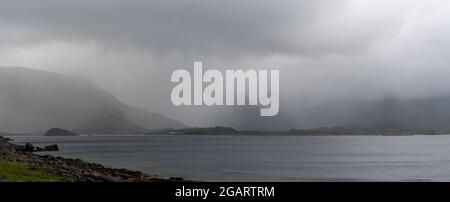 Un panorama d'un fjord mystique et de l'océan Atlantique lors d'une journée d'été trouble et brumeuse dans les îles Lofoten, au nord de la Norvège Banque D'Images