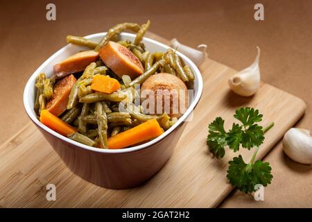 Haricots avec saucisses de porc ragoût sur fond de bois Banque D'Images